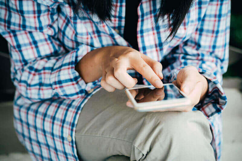 Una persona usa un smartphone mientras consume un vídeo en una plataforma online 